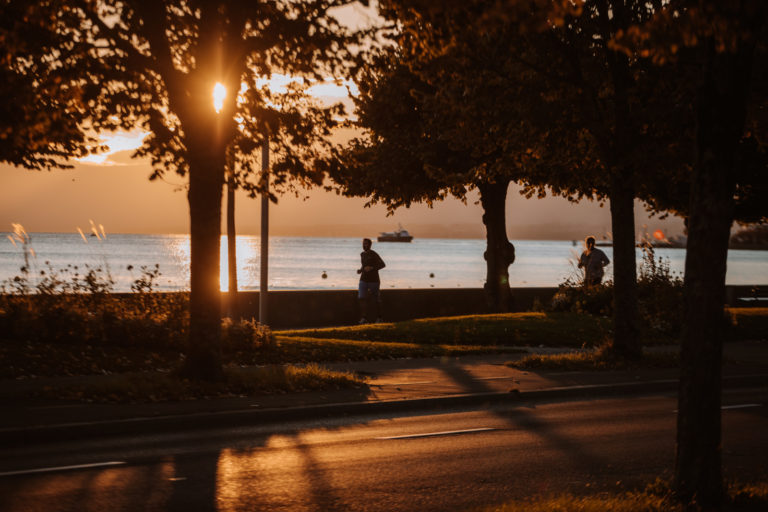 Coureurs au bord du lac au coucher du soleil.
